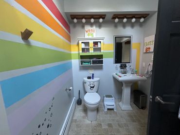 Rainbow stripe mural on bathroom walls