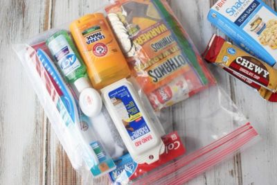 A clear plastic bag packed with travel-sized toiletries and snacks.