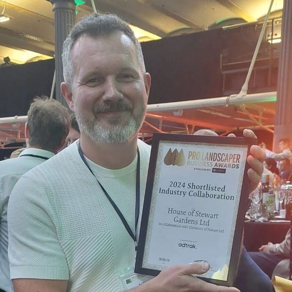 Man holding a framed award plaque.
