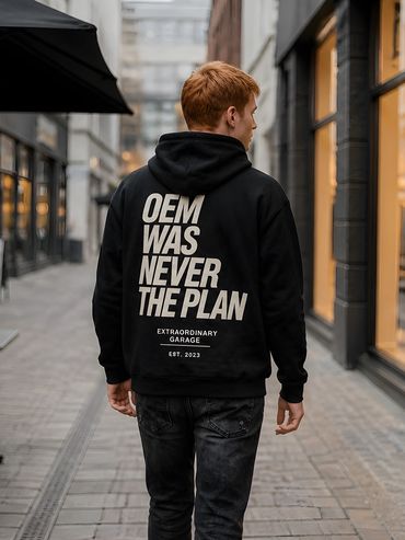 Junger Mann mit schwarzem Kapuzenpullover mit Aufschrift auf dem Rücken.