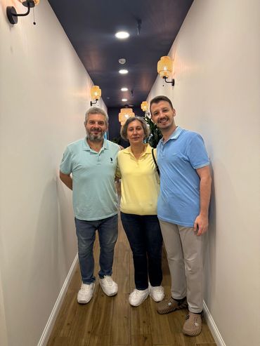 Klinik koridorunda birlikte poz veren 3 kişi