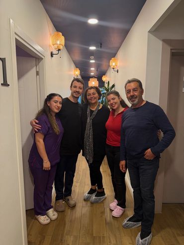 Klinik koridorunda birlikte poz veren 5 kişi
