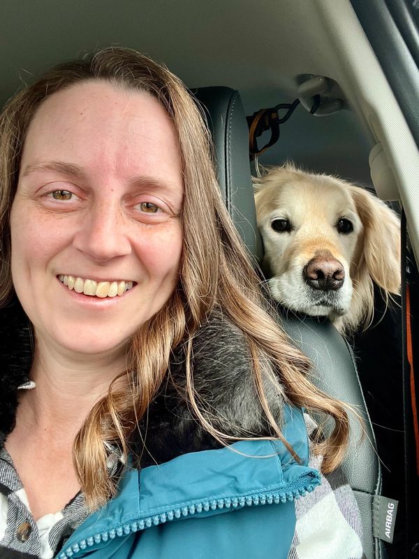 Lauren and Rylee look at the camera smiling, in the car