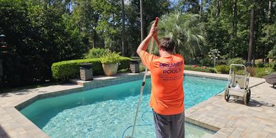 A pool cleaner in Tallahassee Florida performing pool maintenance at a home. Pool cleaning tools.