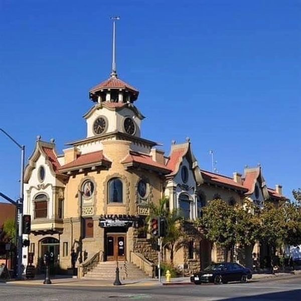 Historic 1905 building with a clock tower under a clear blue sky.