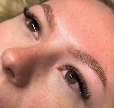 Close-up of a face with green eyes and long eyelashes.