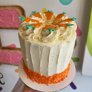 Carrot cwke with orange sprinkles and candy carrots.