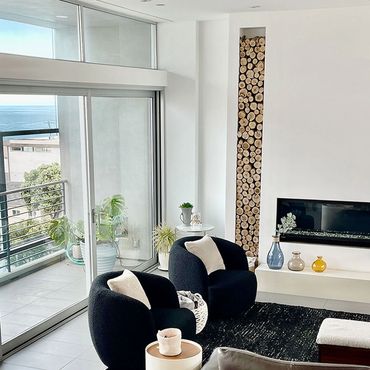Modern living room with black chairs and ocean view. Blue Wave Beach House Luxury Vacation