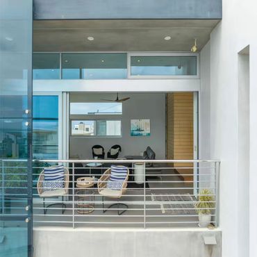 Blue Wave Beach House, Manhattan Beach, CA. 3rd Floor Modern balcony with seating and a view inside the living room.