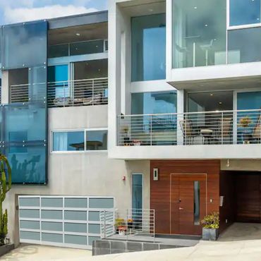 Outside of Blue Wave Beach House, Manhattan Beach, CA Modern house with large windows and a garage.