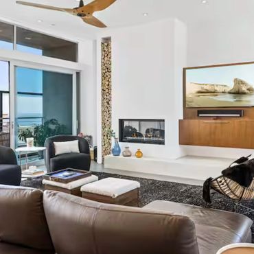 Modern living room with fireplace and ocean view. Blue Wave Beach House Modern Living Vacation Rental
