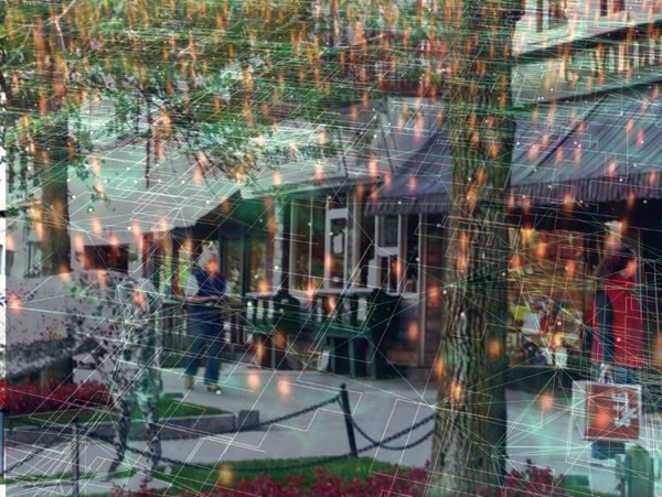 A storefront with outdoor seating, overlaid with digital network graphics.