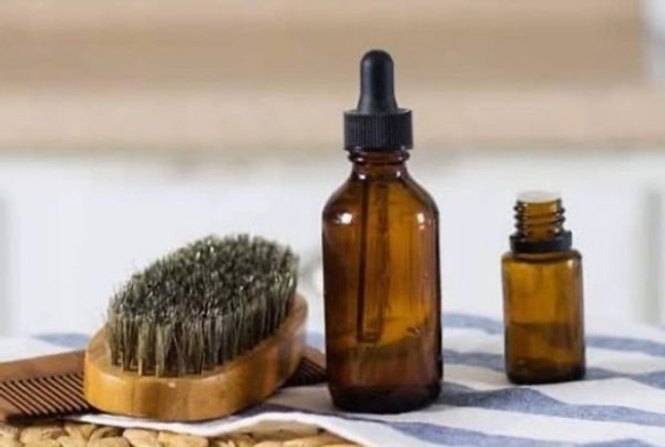 Amber glass bottles with a hairbrush and comb on a towel.