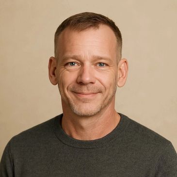 Middle-aged man with short hair and a friendly smile wearing a dark sweater.
