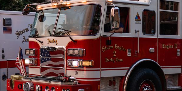 Red and white Derby fire truck with American flag design on grill.