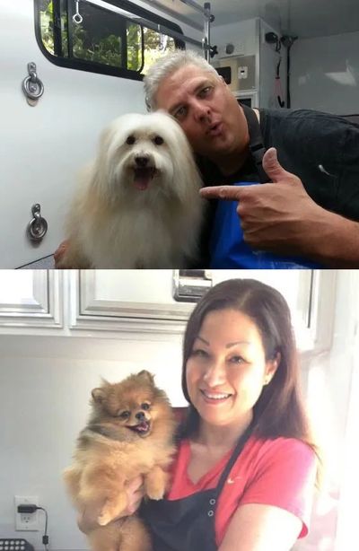 Two people happily posing with their fluffy dogs indoors.