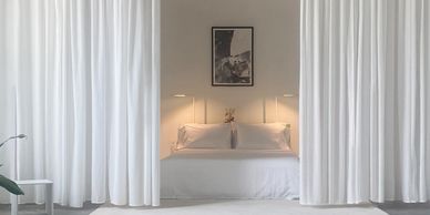 Clean, white, minimal, modern apartment, bedroom concrete floors, open floorplan.