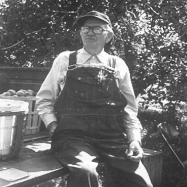 A picture of an old farmer wearing glasses