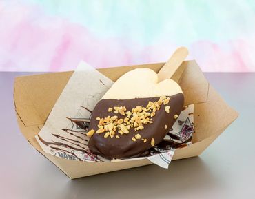 Vanilla Popsicle, dipped in chocolate and topped with your choice of topping