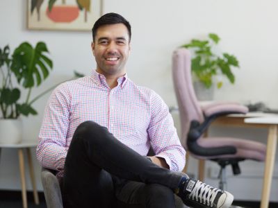 Man in casual shirt sitting comfortably in a modern office space.