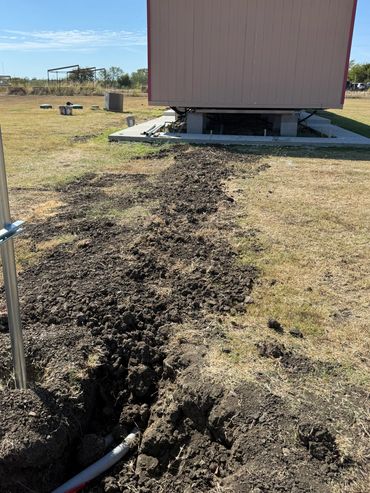 Trench covered for electrical conduit and service from home to outside service meter.