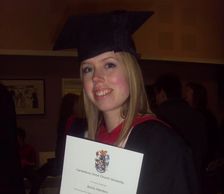 Girl holding a degree, wearing a graduate cap.