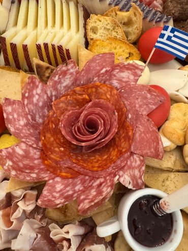 Charcuterie platter with salami arranged like a flower and Greek flag.