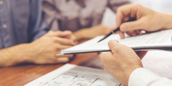 A real estate agent showing a contract to clients