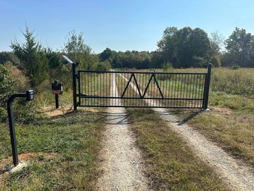 Custom welded steel gate with a gate operator, keypad entry, and remote entry