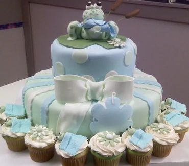 This two tier cake with accompanying cupcakes were made by All About the Cake.