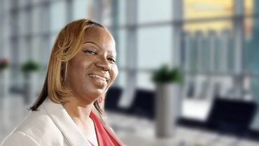 Confident woman smiling in a modern office setting.