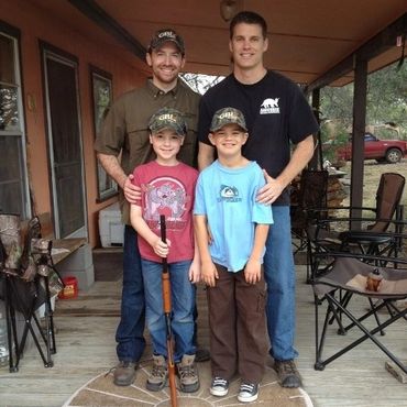2 sets of father and sons on porch with gbl hats on