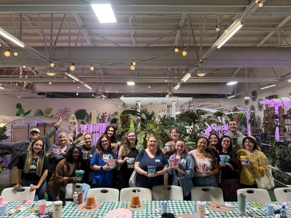 Group photo of people holding colorful crafts indoors.