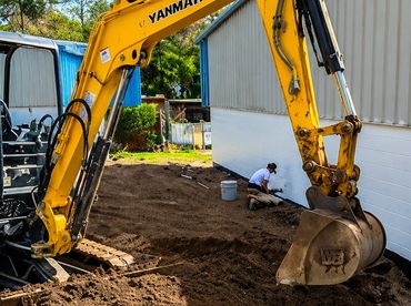 Yellow excavator digging dirt