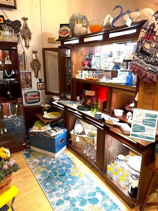 Cozy vintage shop corner with glassware, decor, and collectibles.
