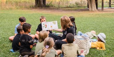 Listening to a story at camp. Forest School programs and camp, Durham Region, ON
