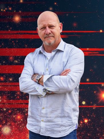 Bald man with a beard stands confidently against a cosmic background with red streaks.