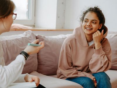 Two women engaged in a friendly conversation on a couch.