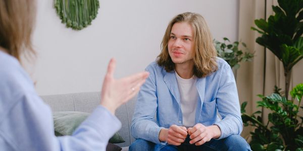A young man attentively listening during a conversation in a cozy living room.