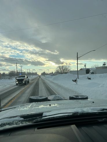 Snowy road view from inside a vehicle during winter.