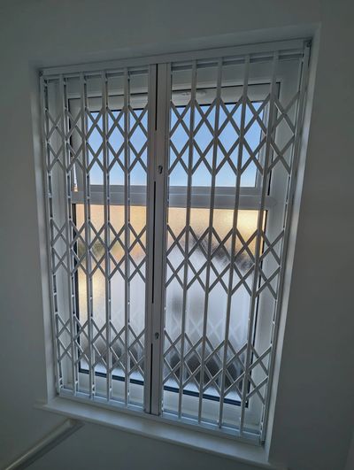 White collapsible window grilles in Harrow