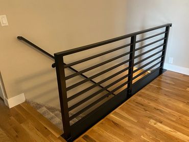 Steel railing with angled steel plate welded on bottom to cover floor end caps