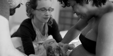 Tara Stratton helping a baby be born in 2014. Kansas City, MO. Photo by, Anecdotally Yours