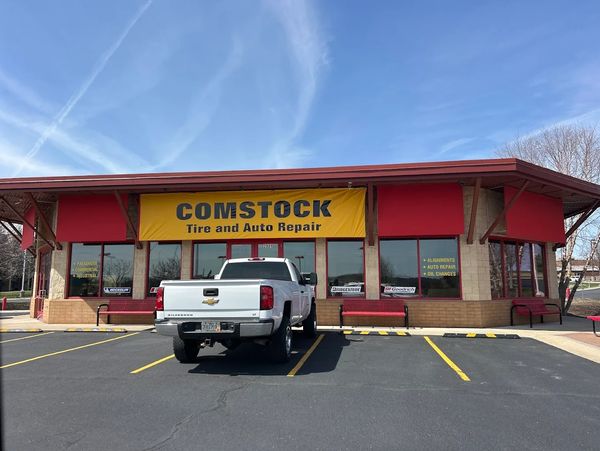 White pickup truck parked outside Comstock Tire and Auto Repair shop.