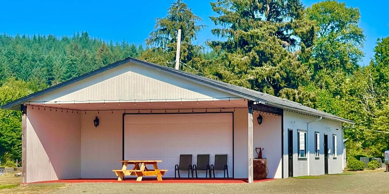 Image outside the clubhouse with a picnic table, three lawn chairs, and a water spicket out front.