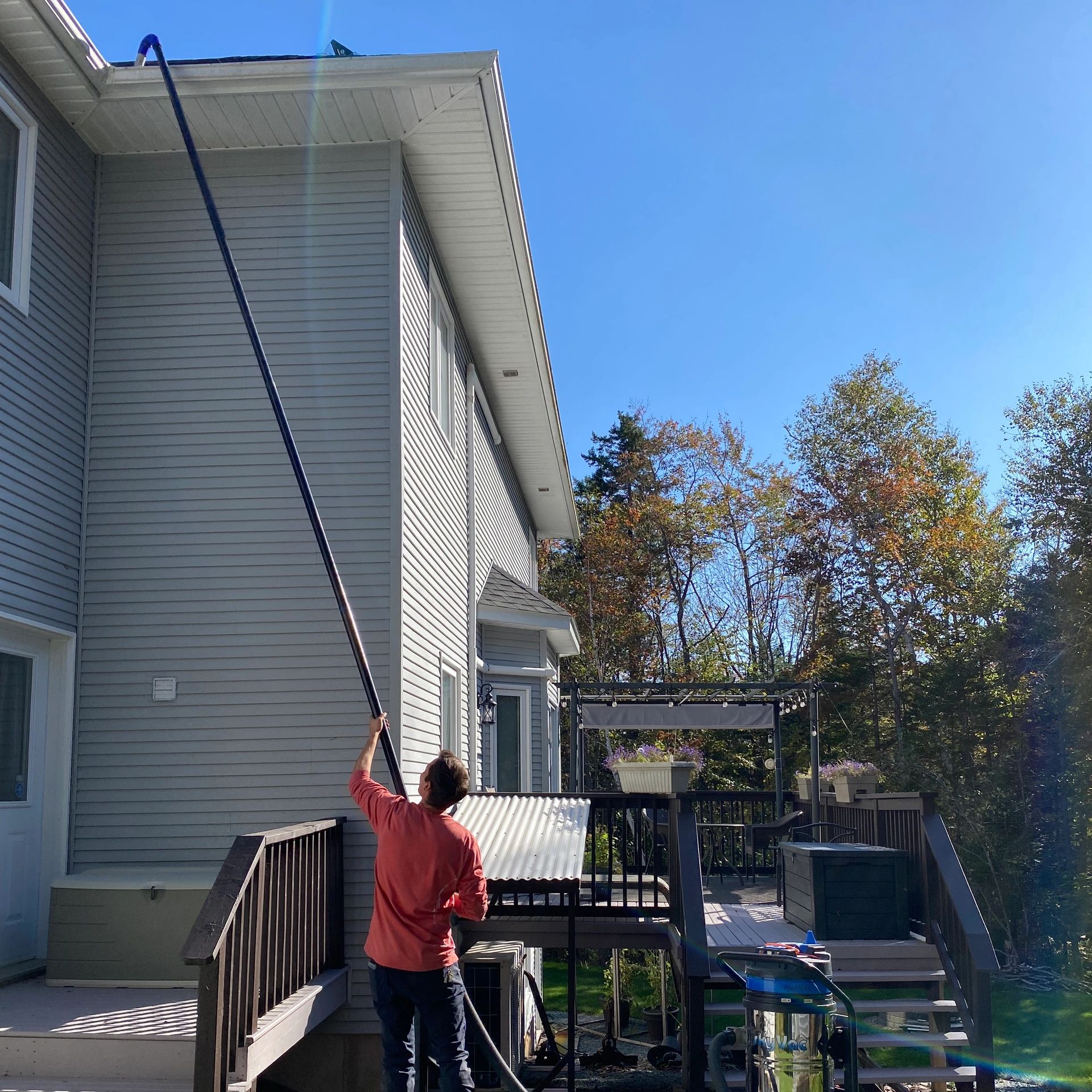 Simon with The Upper Glass doing rain gutter cleaning safely from the ground using a vacuum system.