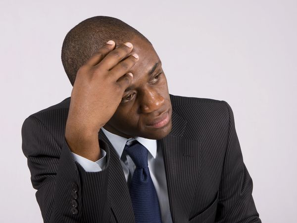 Man in suit looking stressed or thoughtful.