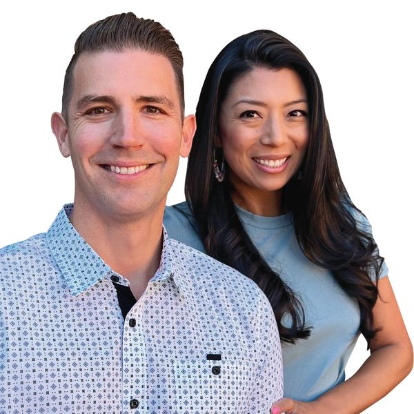Smiling man and woman posing closely together against a white background.