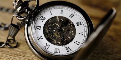 Image of an old fashioned pocket watch, with ornate dial