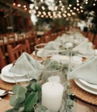 Elegant table setting with candles and greenery for a special event.